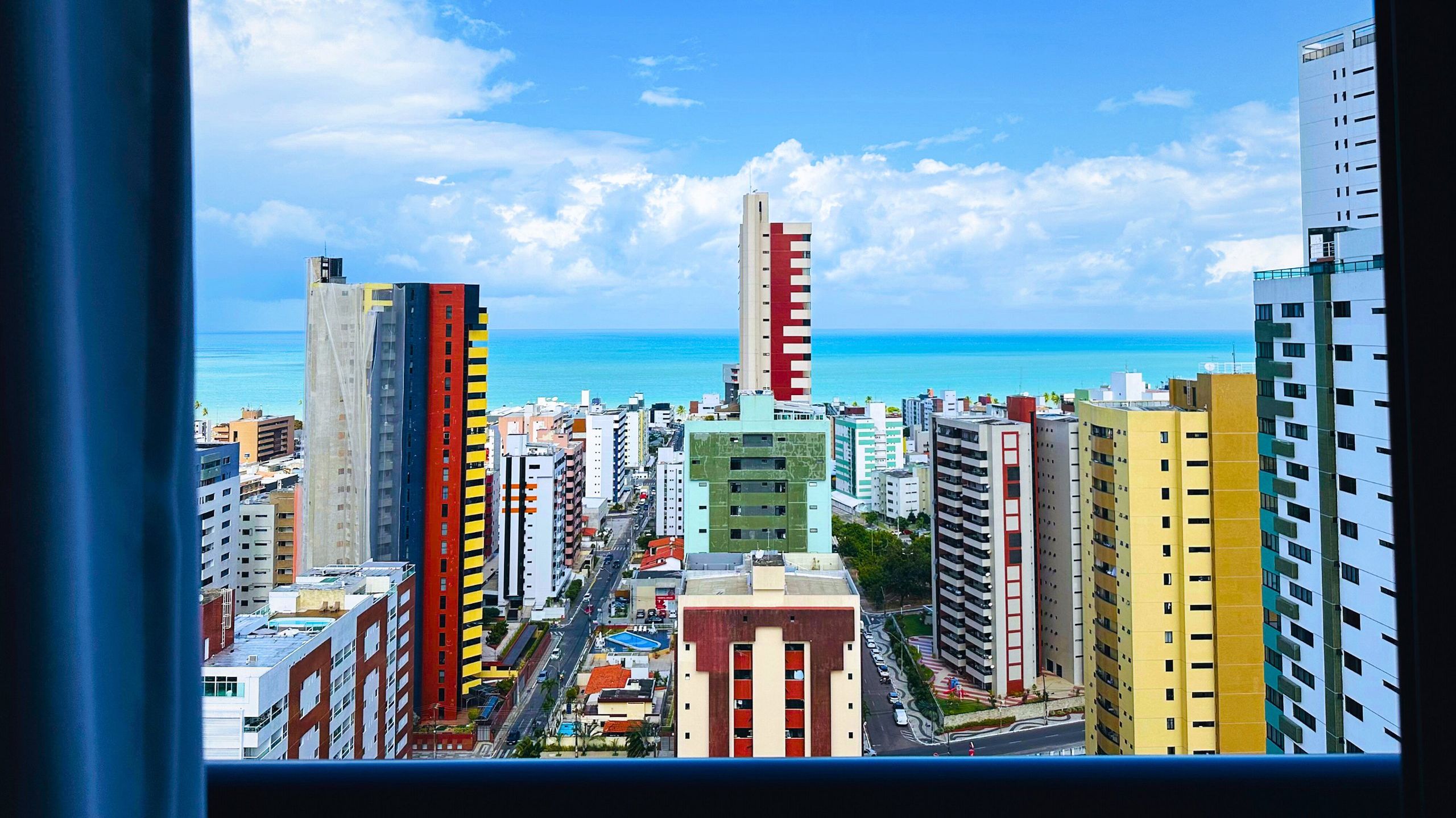 Un horizonte urbano con edificios altos, cielo despejado y vista al océano.