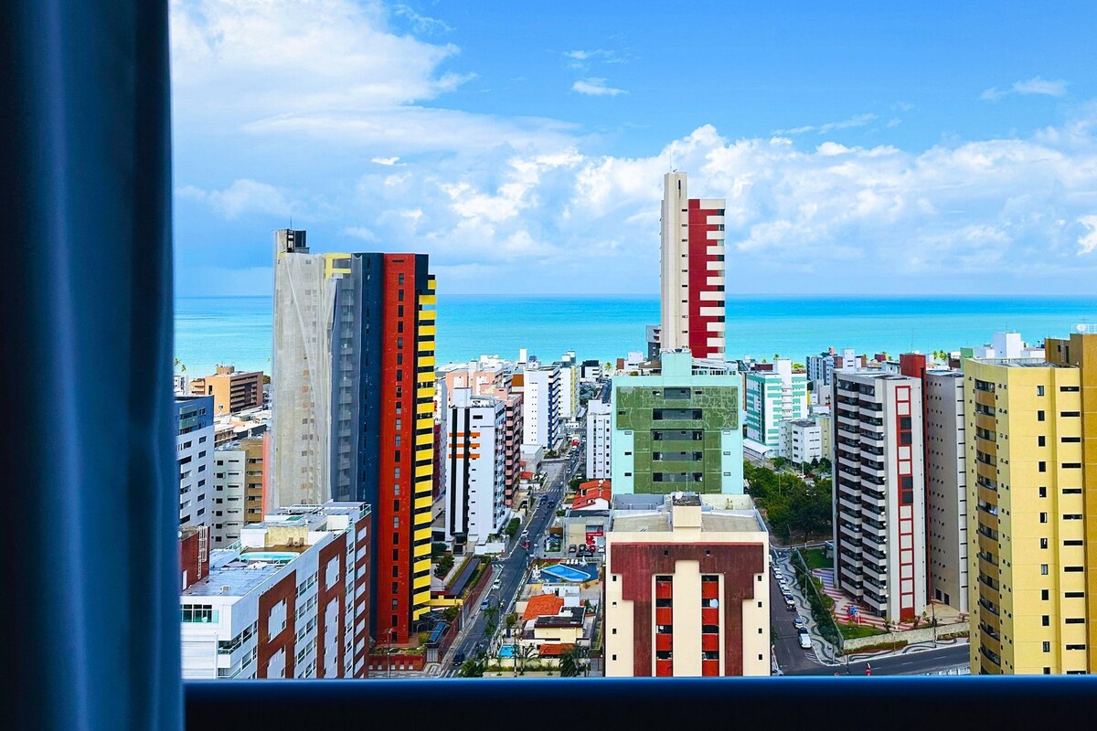 Un horizonte urbano con edificios altos, cielo despejado y vista al océano.
