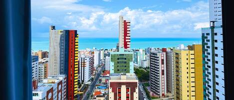 Un horizonte urbano con edificios altos, cielo despejado y vista al océano.