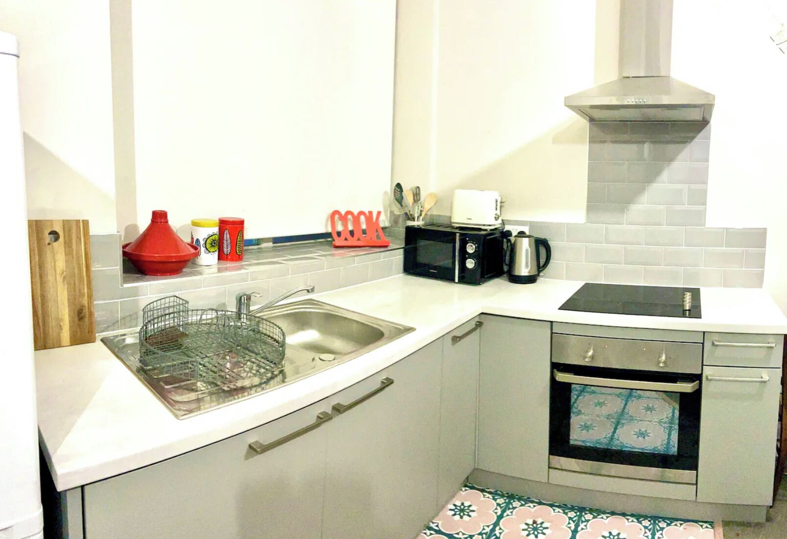Cocina compacta con un lavabo, microondas, tostadora y horno pequeño.