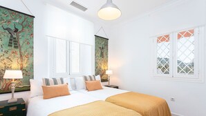 A hotel room with two beds, a window with a view, and artwork on the walls. - Penthouse With Private Terrace Stunning Views Plaza de la Marina (Málaga)