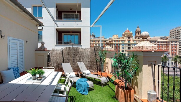 A rooftop terrace with a dining table, lounge chairs, and potted plants. - Penthouse With Private Terrace Stunning Views Plaza de la Marina (Málaga)