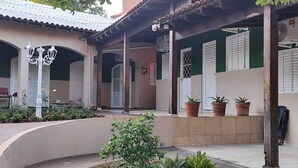 A courtyard with a curved wall, potted plants, and a white lamp post.