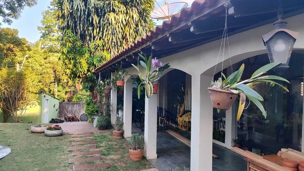 A covered patio area with potted plants and a stone pathway leading to a glass door.