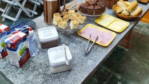 A buffet table with various food items and condiments.