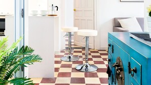 A modern kitchen with a checkered floor, a blue cabinet, and a pendant light. - Private Terrace 5 min Walk to Cathedral 2Bd Apartment Galera II (Seville)