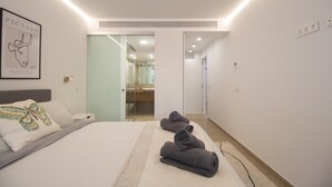 A modern hotel room with a large bed, a bedside table, a mirror, and a framed artwork on the wall. - Sea View Apartment Near The Beach (Fuengirola)