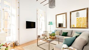 Un salon comprenant un canapé, une table basse et un téléviseur à écran plat.