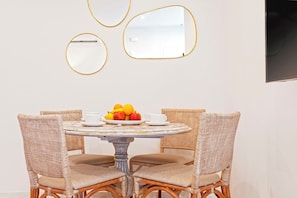 A dining table with wicker chairs, a fruit bowl, and a white cup on it. - Splendid 2 bd Apartment Facing the Cathedral Constituci n II (Seville)