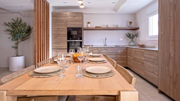 Une cuisine moderne avec des meubles en bois, un four encastré et un évier.
