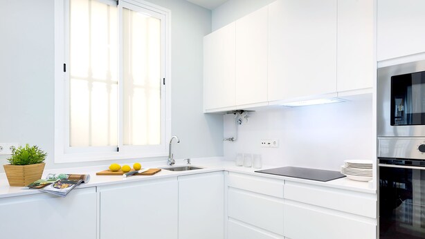 A modern kitchen with white cabinets, a built-in oven, and a window with blinds. - Spacious 3 Bd Apartment With Views to the Metropol Encarnacion (Seville)
