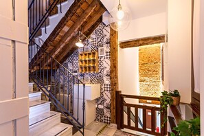 A staircase with a wooden railing, a patterned wall, and a hanging light fixture. - Stunning One-bedroom Apartment Near the Cathedral Zacatin 101 (Granada)