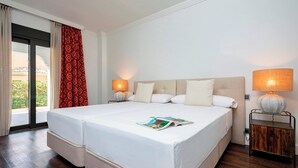 A double bed with a white bedspread, two bedside lamps, and a magazine on the bed. - Spectacular Apartment With Pool and Direct Acces to the Beach Venalmar Terrace (Estepona)