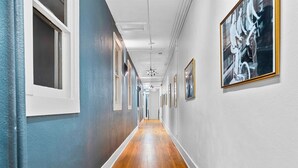 A hallway with wooden flooring, white walls, and framed artwork. - Stylish Loft Retreat in Downtown Hot Springs (Hot Springs)