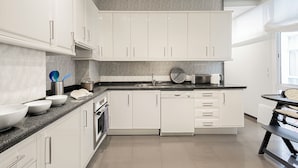 A modern kitchen with white cabinets, a granite countertop, and a built-in oven. - Wonderful Apartment 200m2 - 4 Bedrooms - 3 Bathrooms in the Best Location Albareda (Seville)