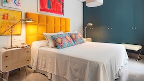 A modern bedroom with a bed, bedside tables, and artwork on the walls. - Wonderful Apartment 200m2 - 4 Bedrooms - 3 Bathrooms in the Best Location Albareda (Seville)