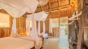 A room with a bed, a bench, and a canopy bed. - Santuario Playa Bonita (Santa Marta)