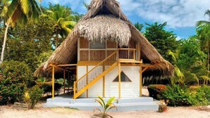 A thatched-roof bungalow with a wooden balcony and a staircase leading to the entrance. - Santuario Playa Bonita (Santa Marta)