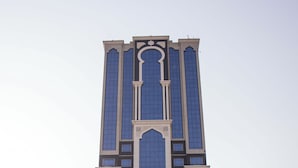 A tall hotel with a modern design, featuring large windows and a central entrance. - Dufla Hotel  (Makkah)