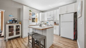 A modern kitchen with white cabinets, a central island, and a built-in oven. - Regal Palms 4BR Home: Water Park Fun! (Davenport)