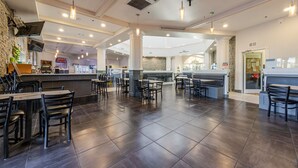 A spacious restaurant with high ceilings, dark flooring, and a central bar area. - Regal Palms 4BR Home: Water Park Fun! (Davenport)