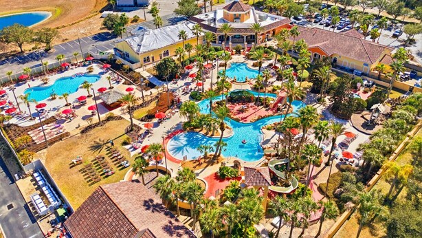 A resort with multiple swimming pools, palm trees, and a large building with a dome. - Regal Palms 4BR Home: Water Park Fun! (Davenport)