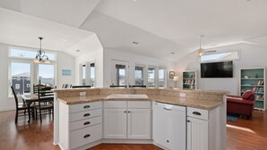 A spacious kitchen with white cabinetry, granite countertops, and a large island. - Semi-Oceanfront, Ocean Views! 225ft to Beach! -Pool, Hot Tub,Pool Table,Dogs OK! (Kitty Hawk)