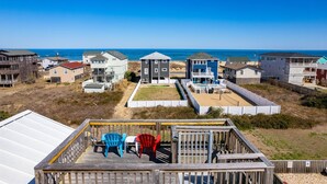 A coastal residential area with houses, a deck with chairs, and a view of the ocean. - Semi-Oceanfront, Ocean Views! 225ft to Beach! -Pool, Hot Tub,Pool Table,Dogs OK! (Kitty Hawk)