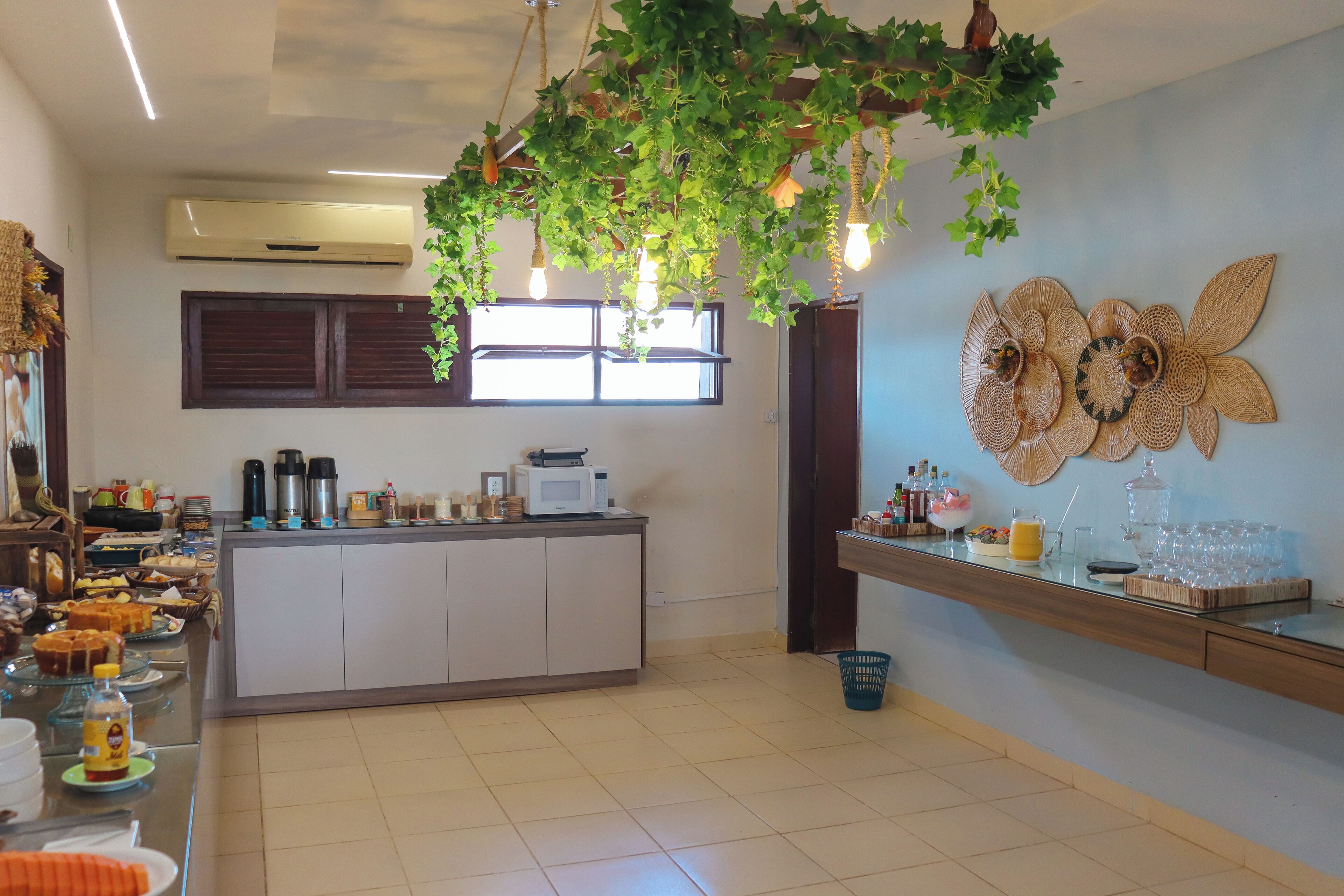 A kitchen with a central island, a window with blinds, a wall-mounted air conditioner, and a decorative wall piece.