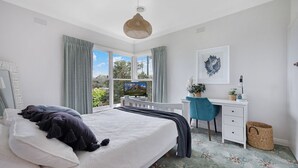 A bedroom with a bed, a desk, a chair, and a window with curtains. - Heritage on Liebig - Perch at the top of town (Warrnambool)