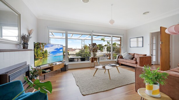 A spacious living room with a large TV, a sofa, a coffee table, and a fireplace. - Heritage on Liebig - Perch at the top of town (Warrnambool)