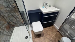 A bathroom with a shower, toilet, and sink. - The Little Tern - A Cosy Coastal Retreat (Lancashire)