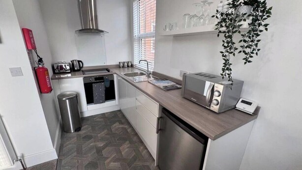 A compact kitchen with a stainless steel toaster, a kettle, and a sink. - The Little Tern - A Cosy Coastal Retreat (Lancashire)