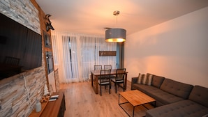 A modern living room with a fireplace, a dining area, and a sofa. - Domizil Alpine Retreat 15 With Balcony (Kaprun)
