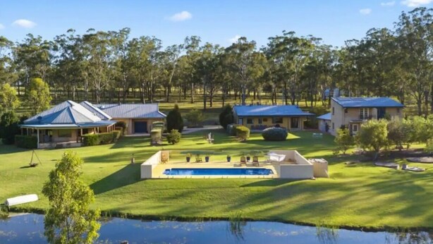 A residential area with houses, a swimming pool, and a pond.