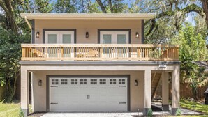 A two-story house with a covered front porch, a garage, and a balcony. - Treehouse Lake Davis - 1BR Private Modern Home with Balcony Downtown (Orlando)