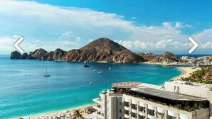 Un hotel costero con vistas al mar, una montaña y una playa.