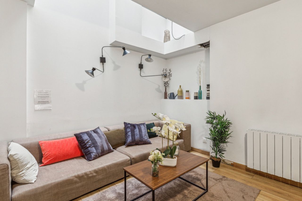 A modern living room with a sofa, coffee table, and decorative items.