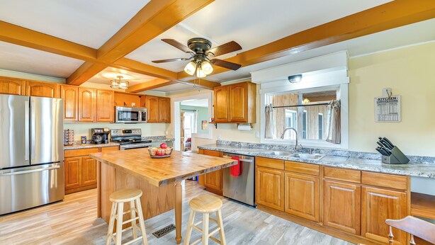 A spacious kitchen with wooden cabinets, stainless steel appliances, and a large island with stools. - 'The Olde Westerlo Village House' - Summer Escape (Westerlo)
