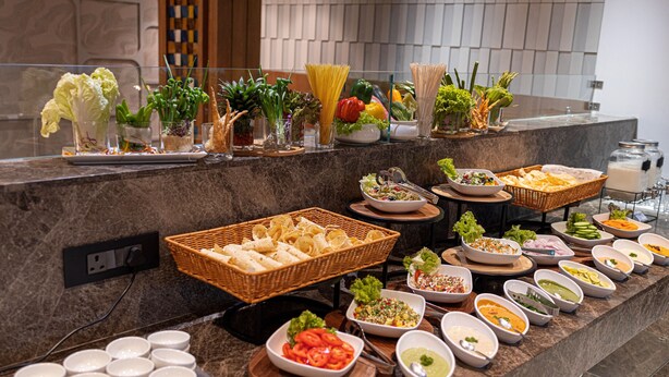 A buffet with various food items and condiments. - Ramada Encore By Wyndham Viramgam (Viramgam)