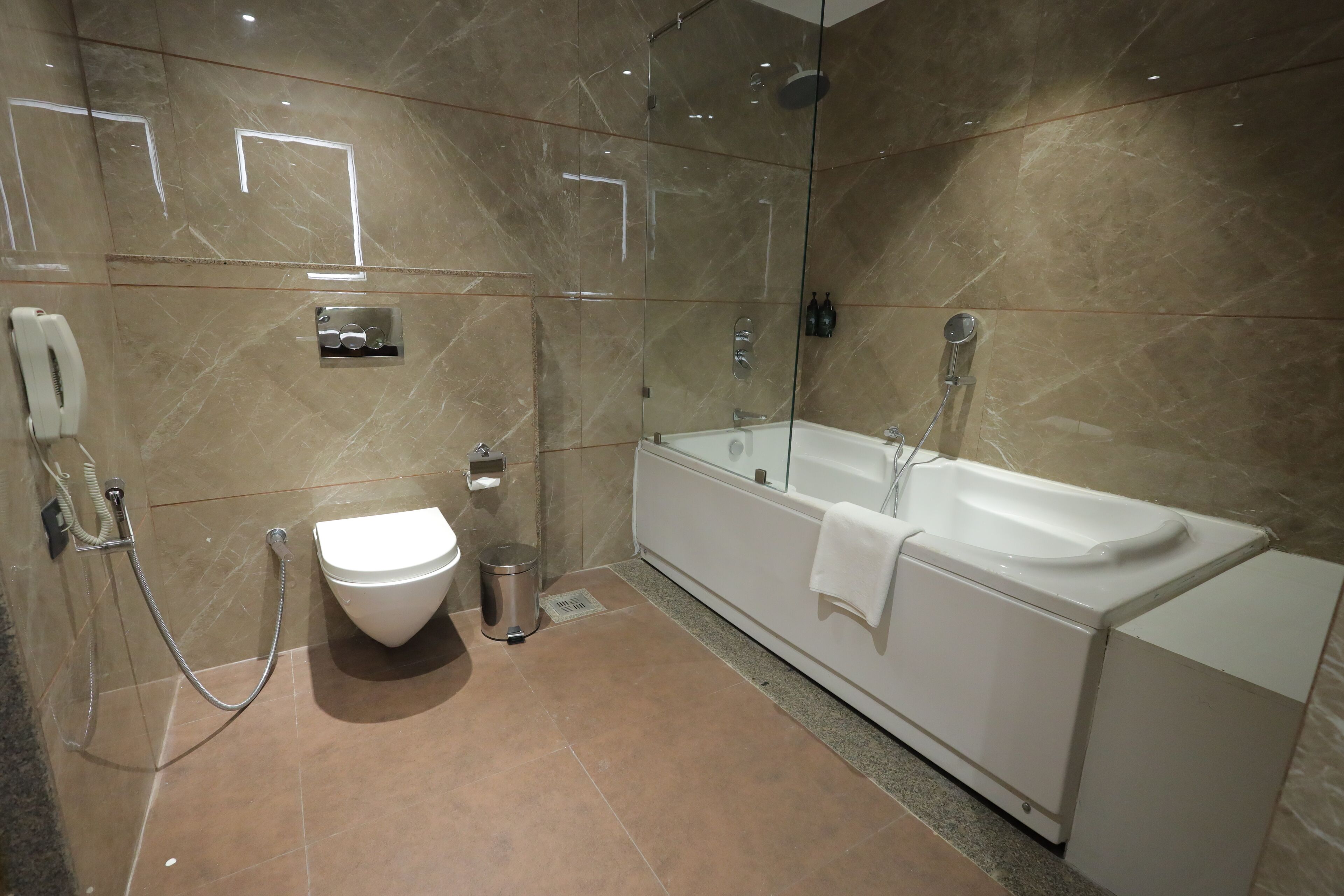 Ein modernes Badezimmer mit Badewanne, Toilette und Dusche.