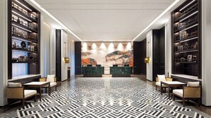 A hotel lobby with a geometric patterned floor, two reception desks, and shelves with various items. - Days Hotel By Wyndham Xianju Downtown (Taizhou)