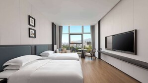A hotel room with two beds, a TV, a small table, and a window with a city view. - Days Hotel By Wyndham Xianju Downtown (Taizhou)