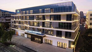 A multi-story hotel with a modern glass facade, signage indicating it is a Wyndham hotel, and a flat roof design. - Days Hotel By Wyndham Xianju Downtown (Taizhou)