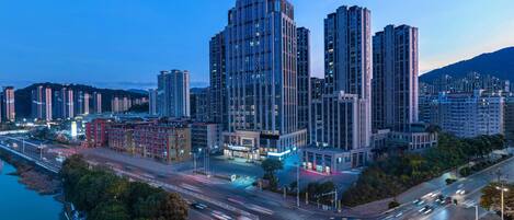A cityscape with modern high-rise buildings, a river, and a busy intersection.