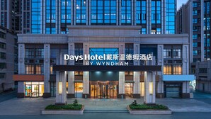 Das Hotel Days Hotel by Wyndham mit moderner Fassade, großen Fenstern und einem markanten Eingang.