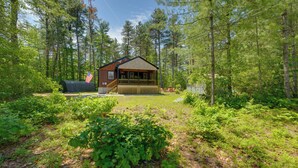 Eine Hütte mit Veranda, umgeben von dichtem Wald.