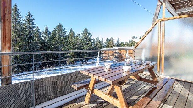 A wooden deck with a picnic table and chairs, overlooking a snowy landscape and forest. - L'Etoile des Neiges - Station de ski à pied (Chamrousse)
