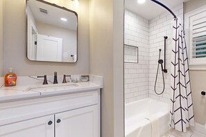 Bathroom features a bathtub, sink, and ample storage.
