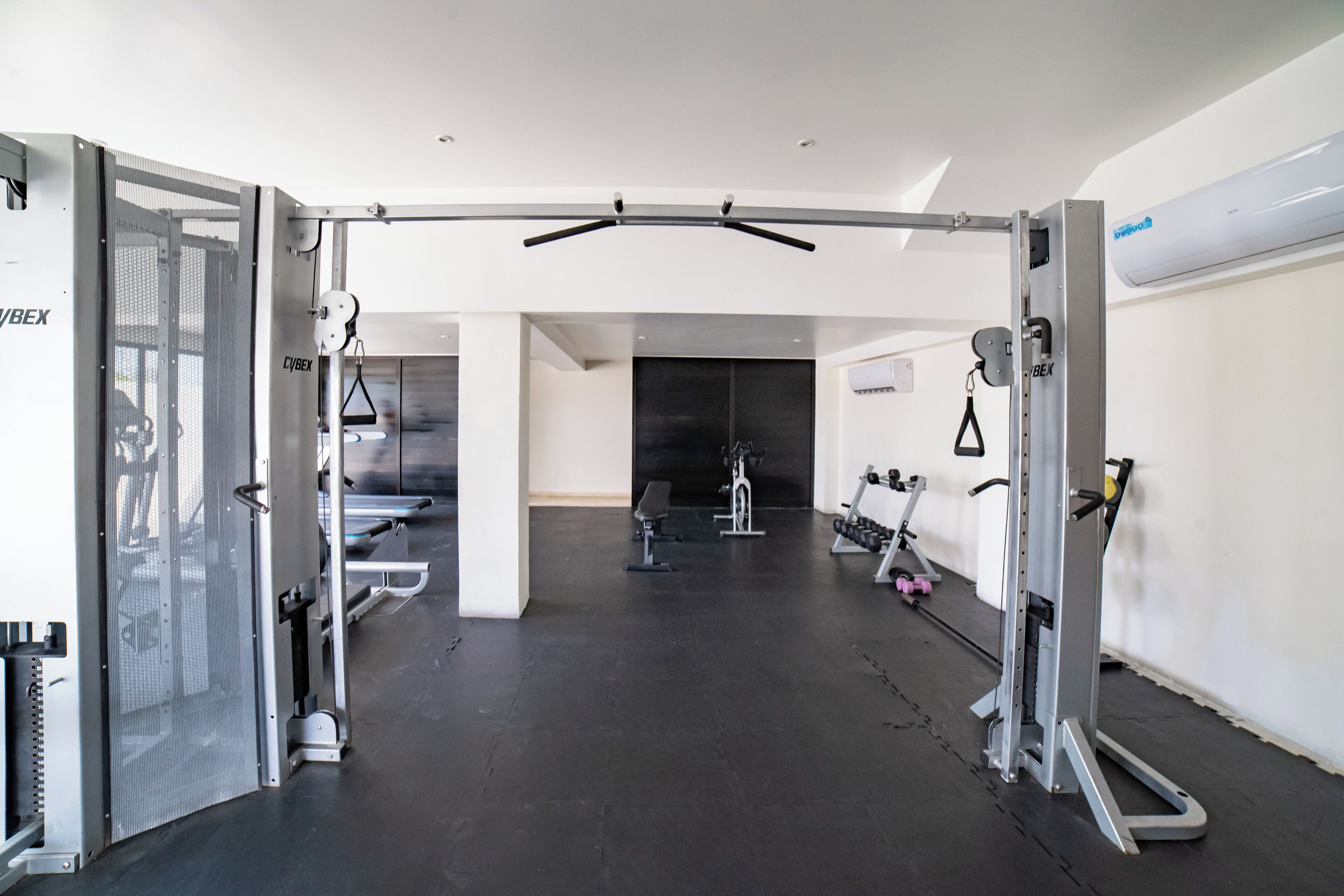 A gym with various exercise equipment, including a pull-up bar, benches, and dumbbells.